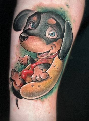 Hot Dog or Scooby Snack? Colored dog animal tattoo by DB. Wyte, a body artist at Iron Palm Tattoos in Atlanta, GA. We love how he made use of a limited color palette. Call 404-973-7828 or stop by for a free consultation to book DB. Wyte. Walk-INs are welcome.