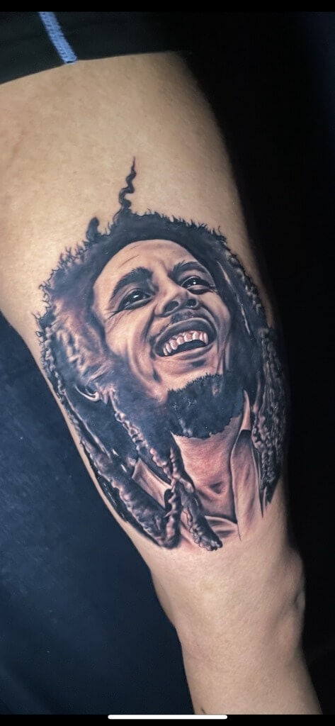 Bob Marley Photo Realism Portatif & Memorial татуировкасы Т Сойердин Iron Palm Tattoos & Body Piercing. Walk Ins кабыл алынат. 404-973-7828 номуруна чалыңыз же бекер консультация алуу үчүн токтоңуз.