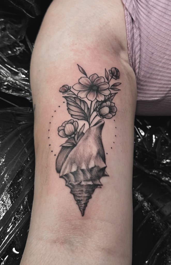 Konk Seashell ak flè nan flè Blackwork Tattoo pa Choze nan Iron Palm Tattoos nan anba lavil Atlanta, Georgia. Kokiy konk senbolize fètilite kòm flè yo ak lavi plant sou sa a tatoo dekri. Atis ki pi ansyen nou an, Choze espesyalize nan tatoo blackwork amann men li metrize anpil lòt estil. Nou se sèlman tatoo nan mitan lannwit lan Atlanta. Rele 404-973-7828 oswa pase pou yon konsiltasyon gratis. Walk Ins yo akeyi.
