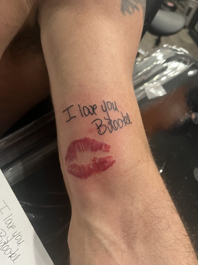 "I Love You Brooke" Lettering With Lips Tattoo By Terrance Sawyer. The sentiment in this tattoo is so apparent 'bad luck' could never happen. Some couples get ink to celebrate anniversaries and others celebrate 'beginnings'. Congrats Brooke. It's forever! 😍 Iron Palm is Atlanta's only late night tattoo shop. We're open from 1PM - 2AM most nights. Call 404-973-7828 or stop by for a free consultation. Walk ins are welcome.