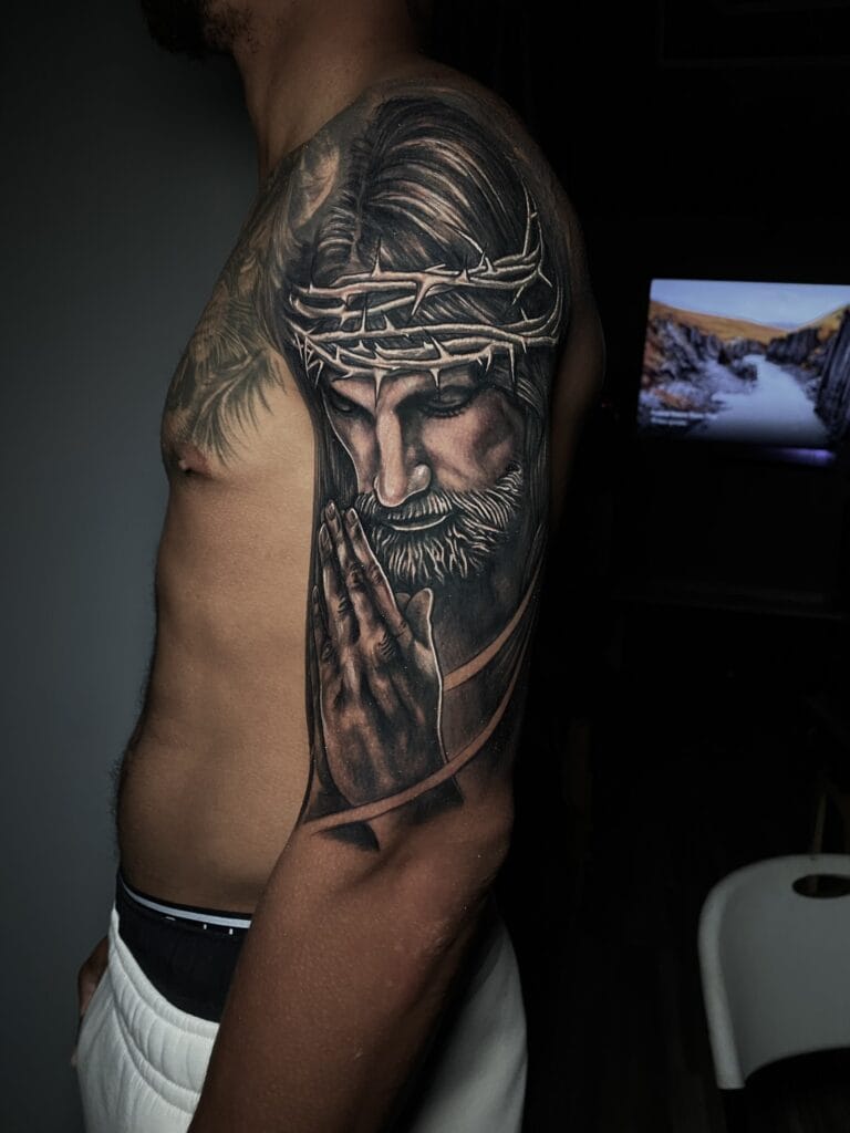 იესო ლოცულობს Blackwork ფოტო რეალიზმის ყდის საფარის ტატუ რენე კრისტობალის მიერ. ჩვენ მოგვწონს რენე კრისტობალის ამ მკლავის დეტალი. რენე არის შავი ფერის ტატუ მხატვარი, რომელიც ცნობილია დეტალური პორტრეტების შექმნით. რენესთან უფასო კონსულტაციისთვის. გაგზავნეთ ტექსტი +1 (678)-926-9731 ან გააჩერეთ. გასეირნება ყოველთვის მისასალმებელია.