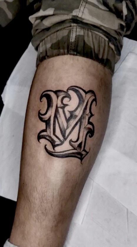 Черная татуировка с надписью «M», сделанная Вивианой Сааведрой. Вивиан — постоянный татуировщик из Чили в Iron Palm Tattoos. Позвоните по телефону 404-973-7828 или зайдите на бесплатную консультацию к Вивиане.