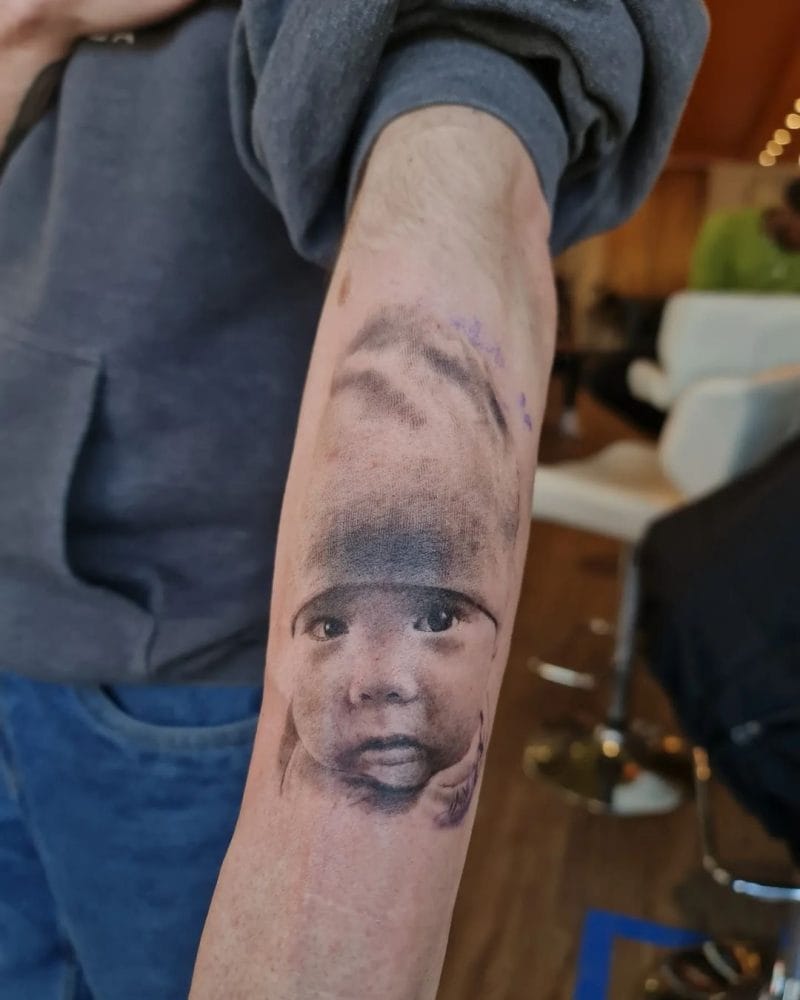 Tatuatge commemoratiu del realisme infantil de fotos negre i gris de Thian. Thian va pintar aquest retrat commemoratiu per a un pare que acaba de perdre el seu fill nounat. Truqueu al 404-973-7828 o passeu per una consulta gratuïta.