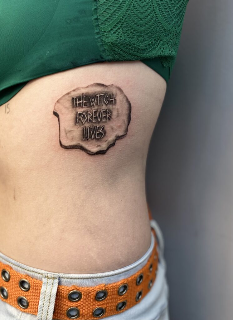 Татуировка The Witch Forever Lives Fear Street Movie от Vivi. Клиентка пришла и показала Виви простой рисунок, объяснив, что это из ее любимого фильма «Улица страха». Поскольку цель рисунка состояла в том, чтобы имитировать камень, Виви нарисовала необходимые детали, чтобы камень выглядел реальным, с вытатуированной на нем фразой. Позвоните по телефону 404-973-7828 или зайдите на бесплатную консультацию. Проходы приветствуются.