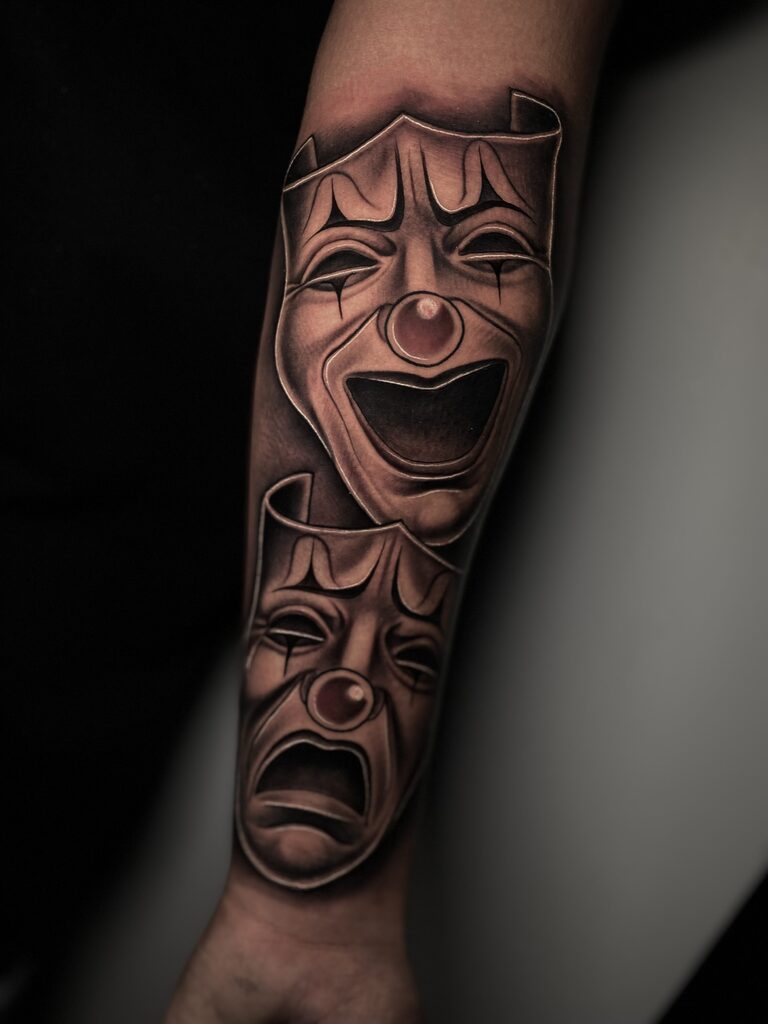 "Lag nou. Huil later" Komedie en tragedie Swartwerk-tatoeëermerk deur Rene Cristobal.