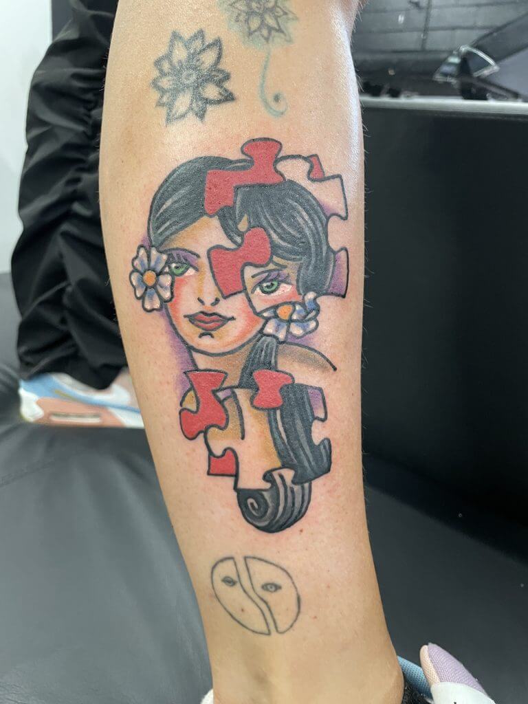 Tatwaġġ ta' Puzzle ta' Tifla Tradizzjonali Amerikana minn Tupicalo f'Iron Palm Tattoos. Ċempel 404-973-7828 jew żurna għal konsultazzjoni bla ħlas. Nilqgħu nies mingħajr appuntament.