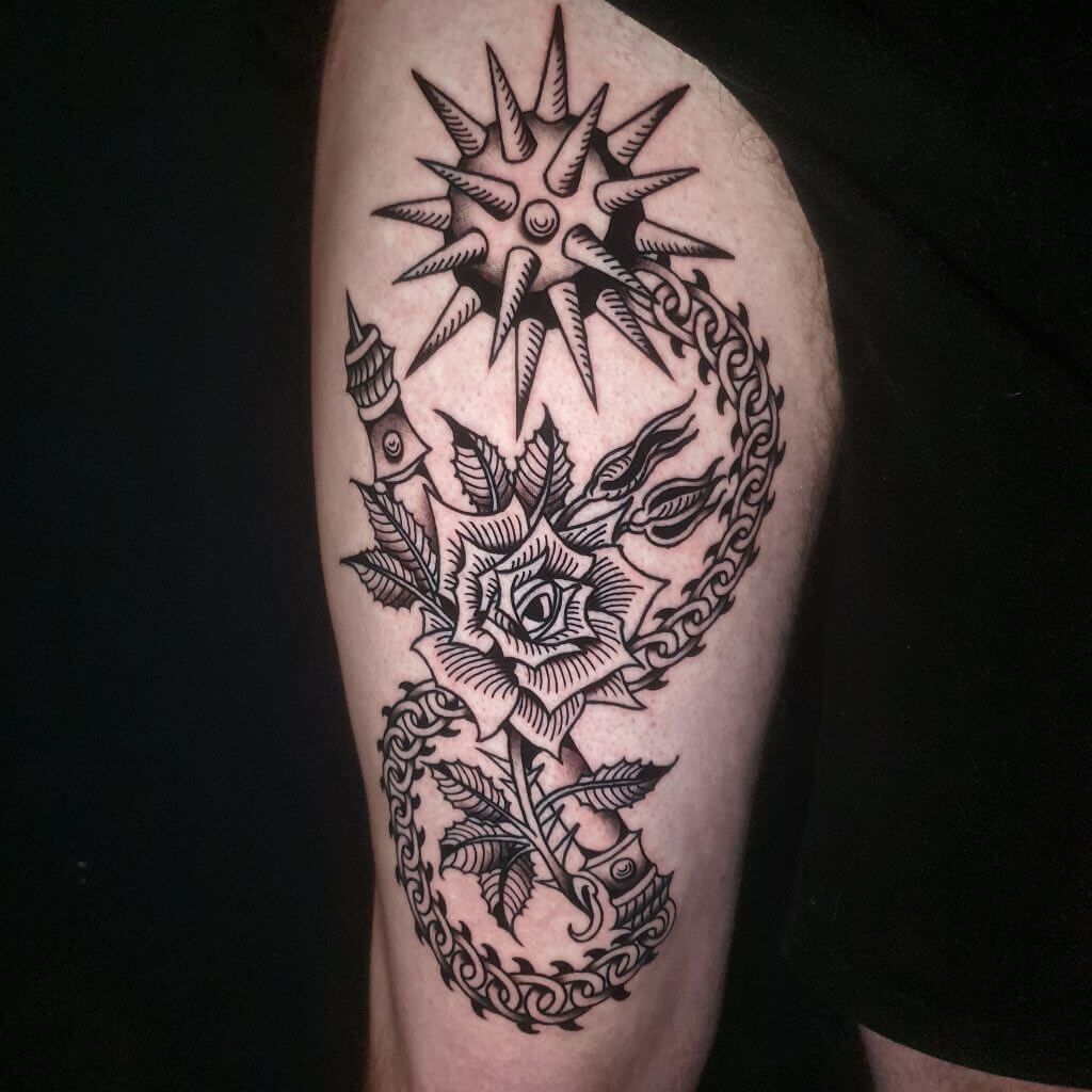 Moso sa a te fèt kòm yon fizyon mitik zam ak senbolis botanik, ki soti nan tradisyon gravur medyeval yo ak ikonografi fantezi nwa. Nan sant la gen yon roz nwa, estilize ak fèy ki gen bor byen file ak lonbraj pwentiye, antoure pa yon chenn espiral tankou yon sèpan pikan. Anlè roz la gen yon tèt fwèt pike ki fèt tankou yon solèy, ki melanje senbolis diven ak fòs destriktif. Kache nan mitan petal yo ak lyen yo gen yon ponya, yon woulo liv, ak lòt eleman ki sanble ak relik - chak plase pou evoke yon istwa bote, danje, ak dezòd sakre. Tout konpozisyon an te fèt ak liy fonse ak teksti pwentiye, ki fè referans a tou de estil gravur ak tatoo tradisyonèl yo. Se yon moso sou kontras: elegans ak britalite, lanati ak zam, limyè ak menas - ini nan yon sèl anblèm dekoratif.