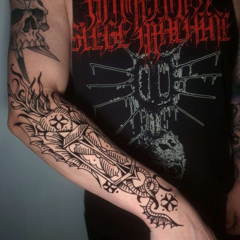 Tattoo gacanta hore waa tarjumaaddayda xusuusta memento mori, oo loo qaabeeyey saamaynta farsamooyinka xaradhka iyo farshaxankii hore ee Yurubta dhexe. Xarunteeda waxaa ku yaal muraayad-saacad fidsan, oo astaan u ah dhimashada iyo waqtiga lumaya, oo ay u qaabaysan yihiin caleen summaysan oo ay garab taagan yihiin quluubta xurmada leh oo gubanaysa. Ololka ayaa kor u kaca, isagoo ka tarjumaya kor u kaca ruuxiga ah iyo qudhunka lama huraanka ah - dheelitirnaanta quruxda leh ee iftiinka iyo aan joogtada ahayn. Halabuurka waxaan u dhigay mid geesinnimo leh oo qaabaysan, anigoo isticmaalaya qaabab xariiq madow oo xusuusinaya alwaaxyo-qoriyihii dhexe iyo sawir-gacmeedyada. Qaybta oo dhami waxay dareemaa sidii farshaxan wakhti kale soo baxay, oo loo xidhay sida hubka, oo u digaya kan xidhan iyo daawadeyaashaba si isku mid ah: wakhtigu wax walba wuu cunaa.