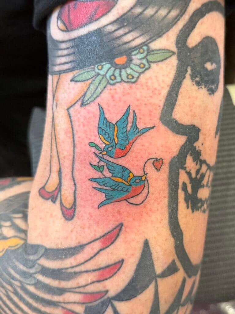 Jahnova și-a tatuat tatuajul tradițional american Love Birds, bazat pe propriul model flash de tatuaj, care a atras atenția unui cuplu. Cu o pasiune pentru arta atemporală, Jahnova aduce la viață modele clasice cu culori vibrante și linii fine. Ea oferă consultații gratuite pentru a ajuta clienții să-și transforme ideile creative în opere de artă durabile. Sunați astăzi la 404-973-7828 pentru a programa o consultație gratuită cu Jahnova și a explora modele personalizate de tatuaje tradiționale americane.