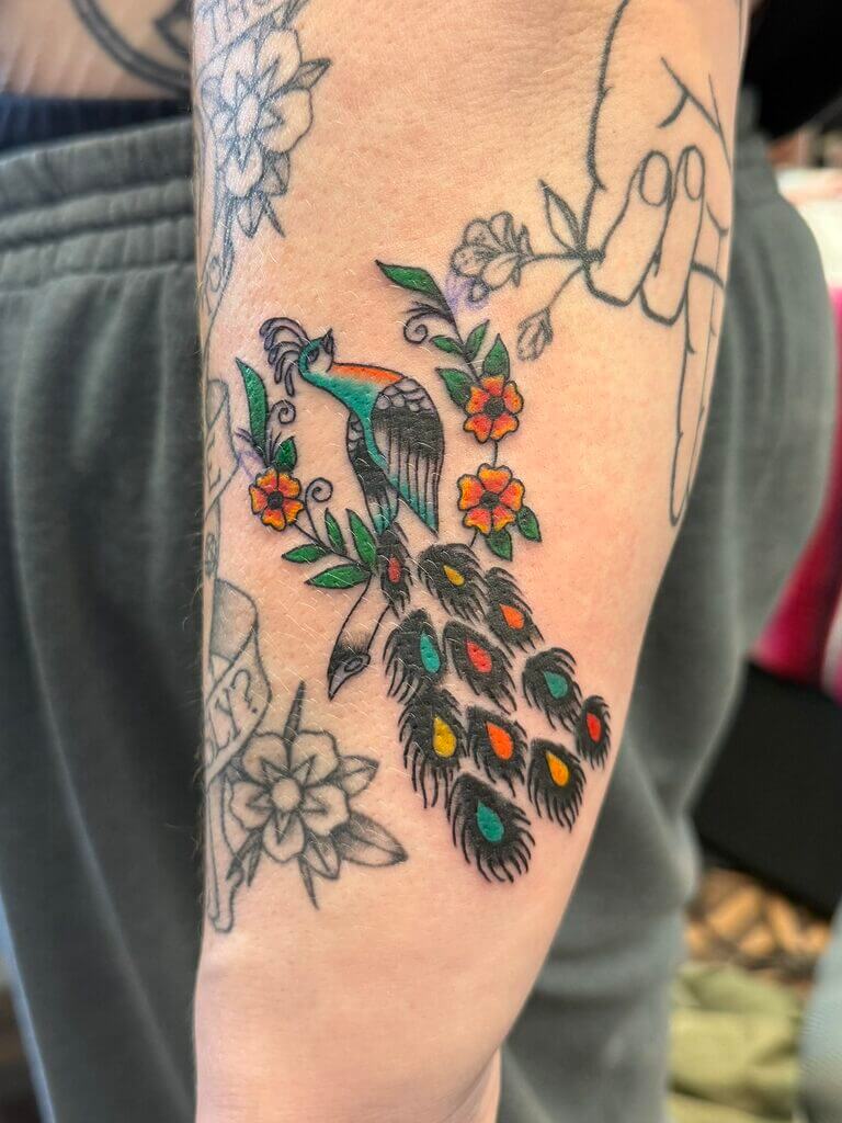 Tatuaj floral cu păsări păun De Jahnova, clienta Jahnova s-a simțit atrasă de tatuajul ei flash cu păun și astfel i l-a tatuat pentru ea.